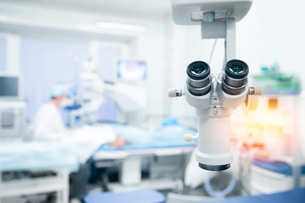Advanced ophthalmic microscope in a sterile surgical room, highlighting high-tech equipment used during precision eye surgeries like LASIK or cataract.