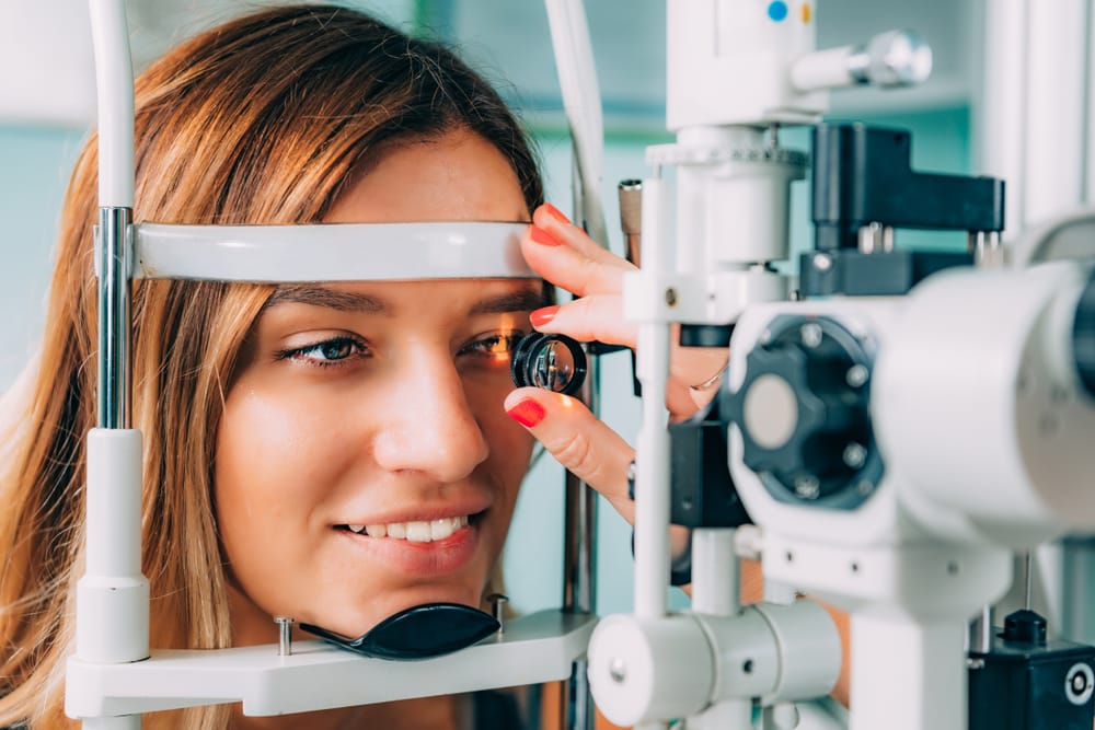 Young woman undergoing a slit lamp eye exam during a routine vision check-up, highlighting precision diagnostics in modern optometry clinics.