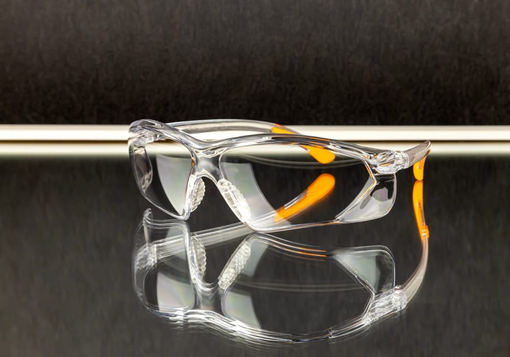 High-quality clear safety glasses with orange accents, designed for optimal eye protection in laboratory, industrial, or medical environments.