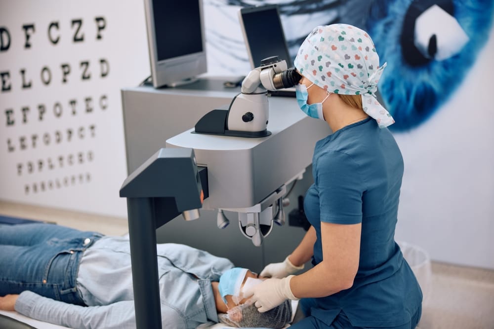 Eye care specialist preparing patient for LASIK surgery using advanced diagnostic equipment in a modern ophthalmology clinic setting.